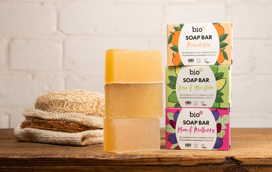 Bio-d natural plum and mulberry solid soap bar surrounded by plums