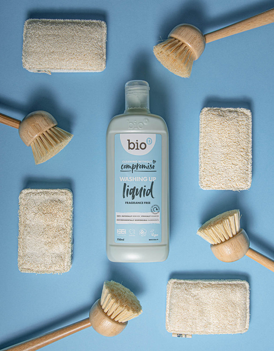 Bio-D Fragrance Free natural vegan friendly Washing Up Liquid in a 750ml bottle pictured on a blue back ground with wooden dish brushes and natural sponges