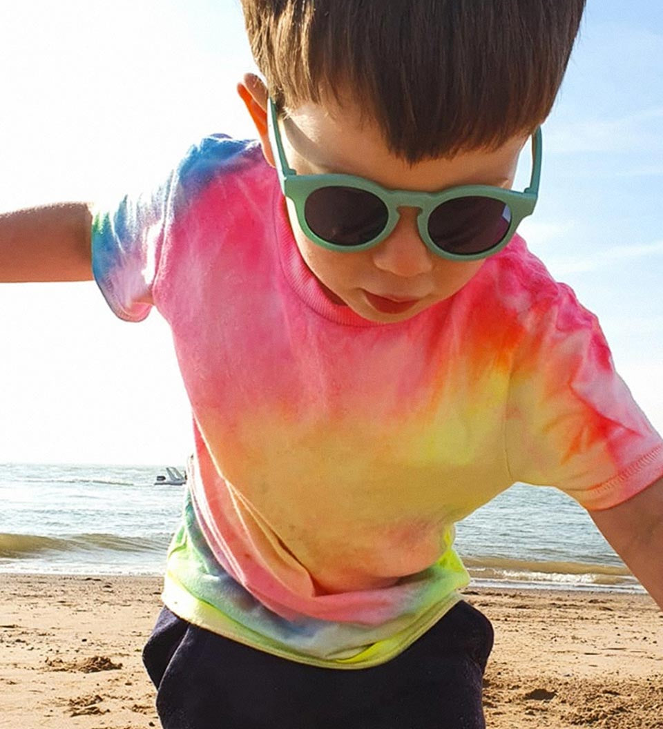 Close up of young boy wearing the Bird flexible childrens sunglasses on a beach