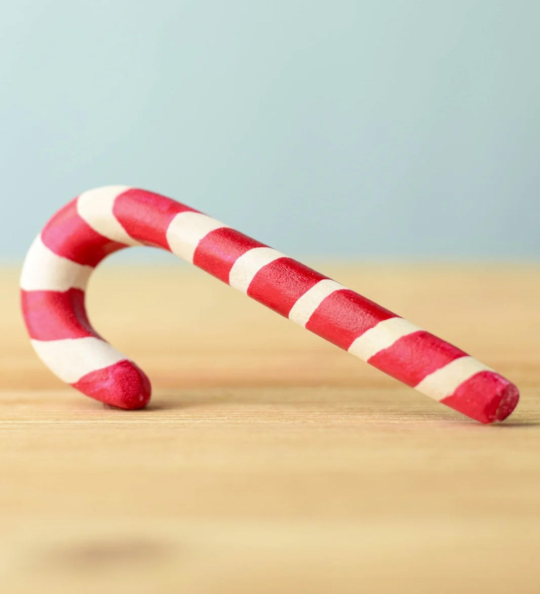 A red and white wooden Bumbu candy cane