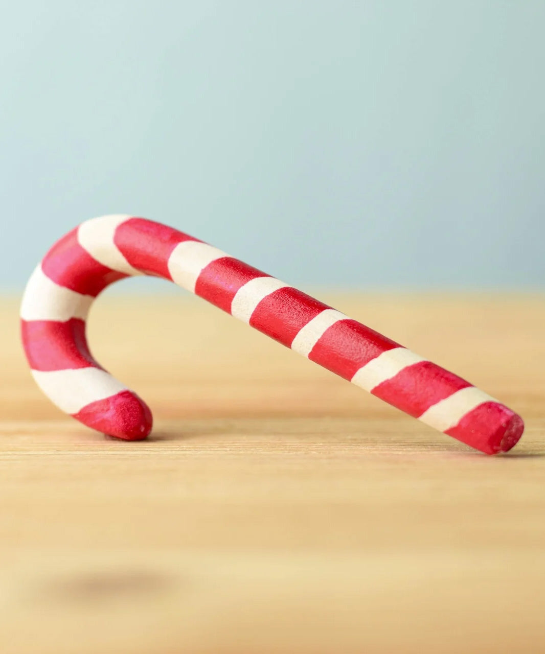 A red and white wooden Bumbu candy cane