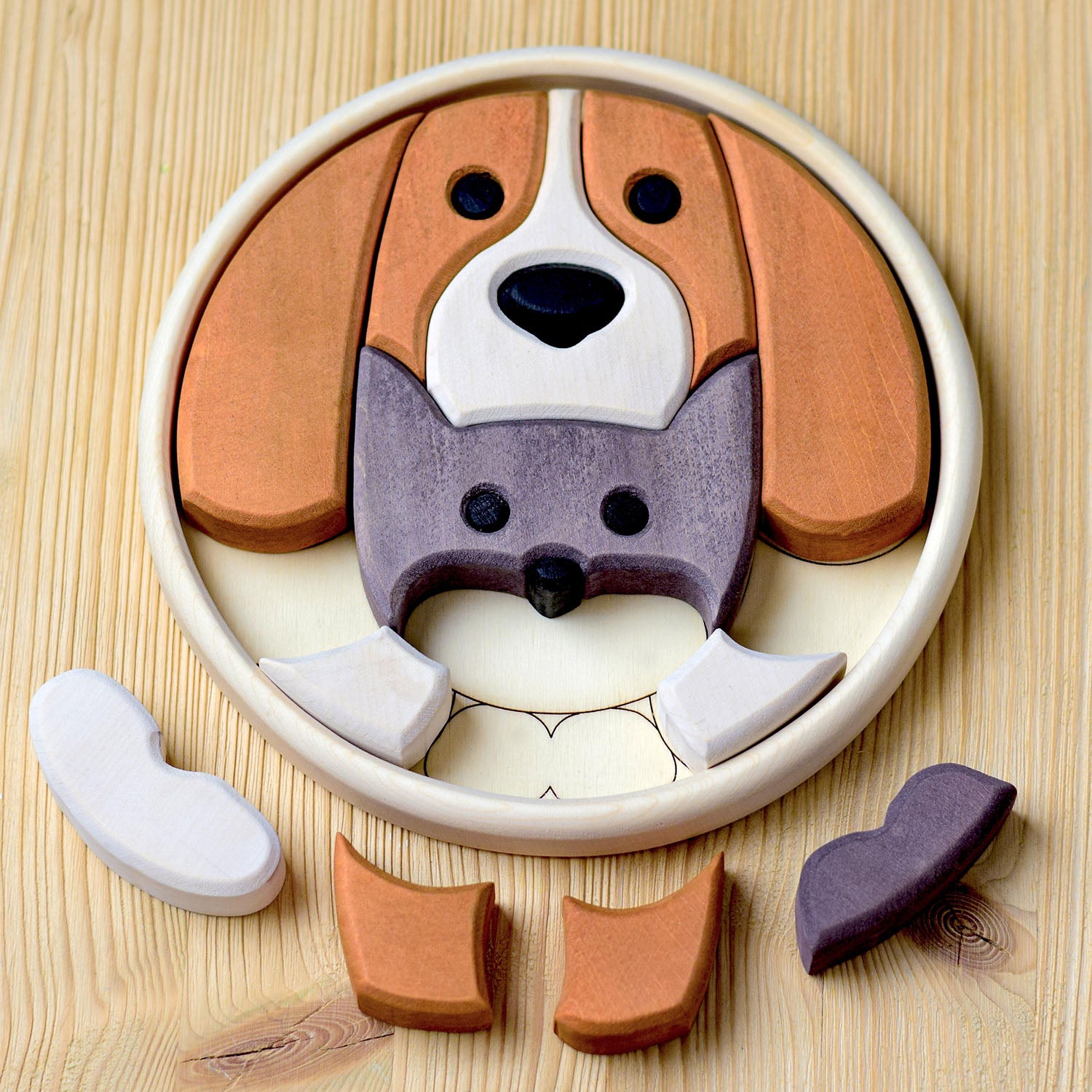 dog and cat wooden puzzle with some bottom pieces removed to reveal the round wooden base that houses the pieces.