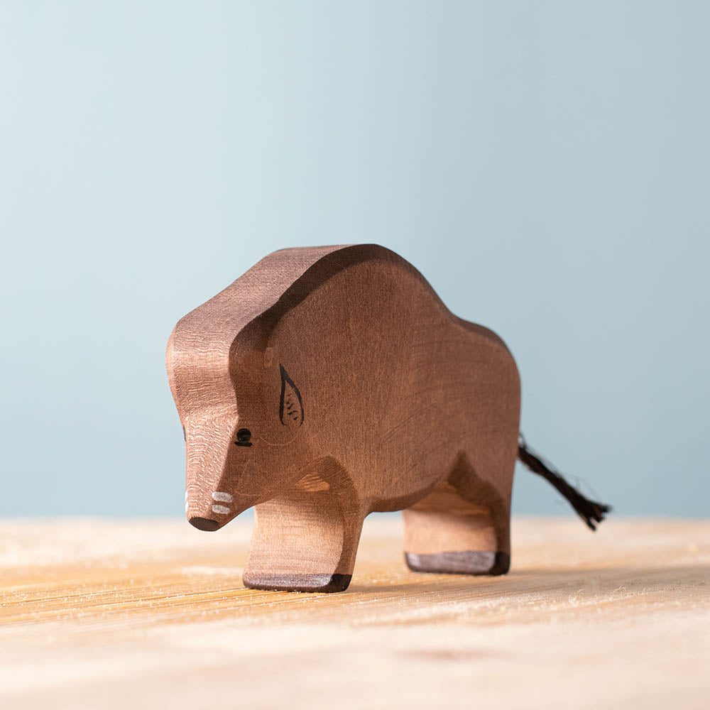 Close up of the Bumbu handmade wooden wild boar figure on a wooden worktop