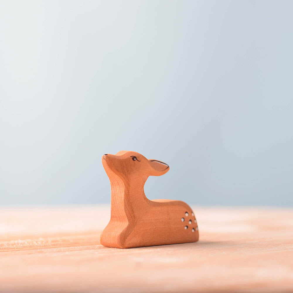 Close up of the Bumbu brown resting fawn toy figure on a wooden background