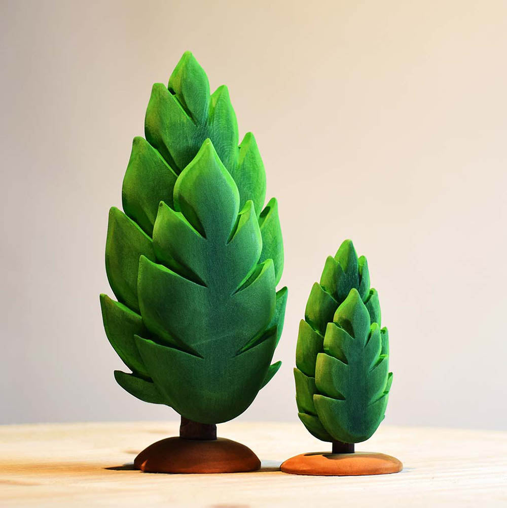 Close up of the small and large Bumbu wooden thuja tree toys on a wooden table