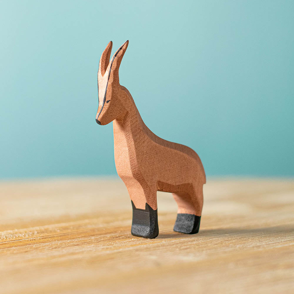 Bumbu handmade wooden mountain goat animal figure on a wooden table