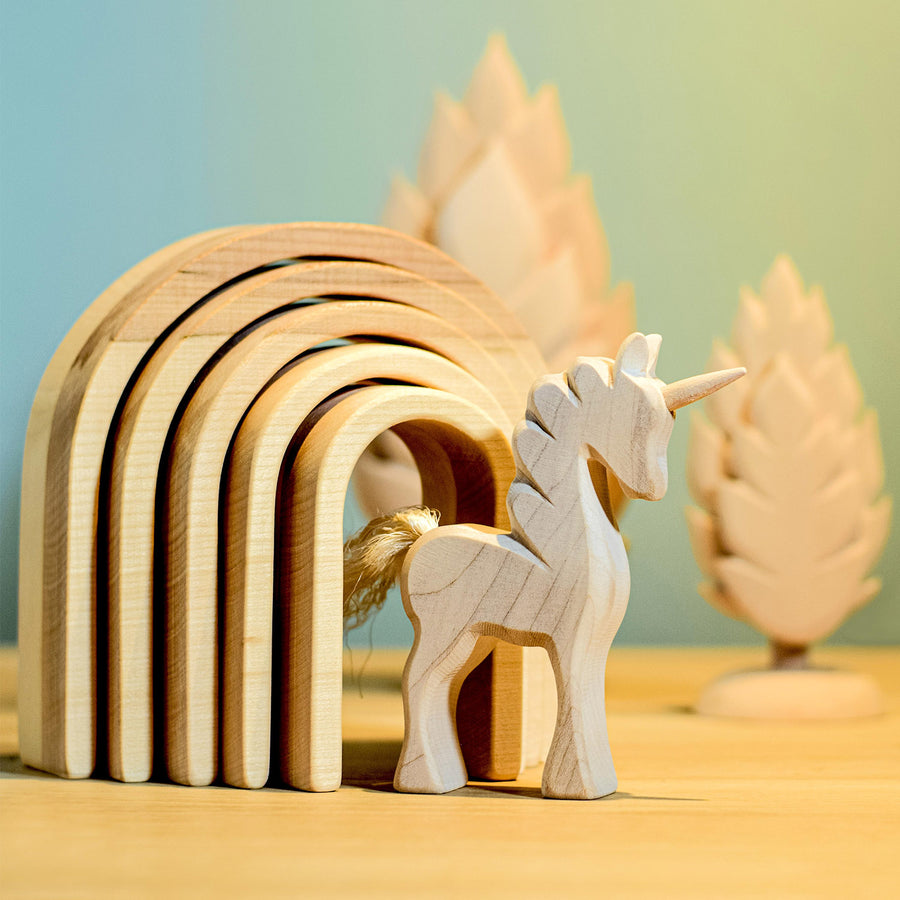 Bumbu Natural Wooden Stacking Arches. A child stacks the arches in a home setting.