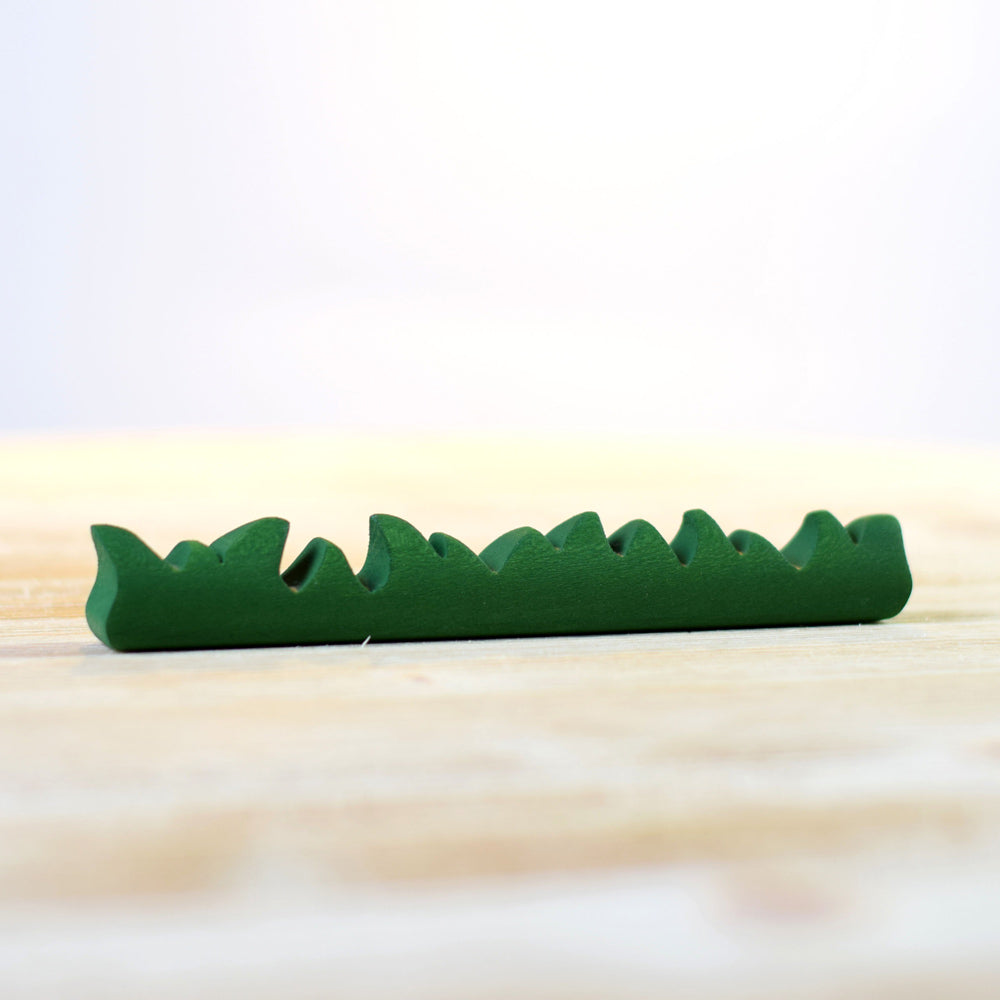 Close up of the Bumbu large wooden grass toy on a white wooden background