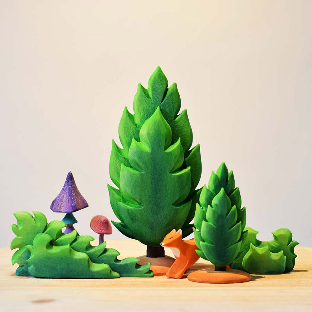 Bumbu eco-friendly wooden shrub bush toys on a wooden worktop next to the green Thuja tree toys