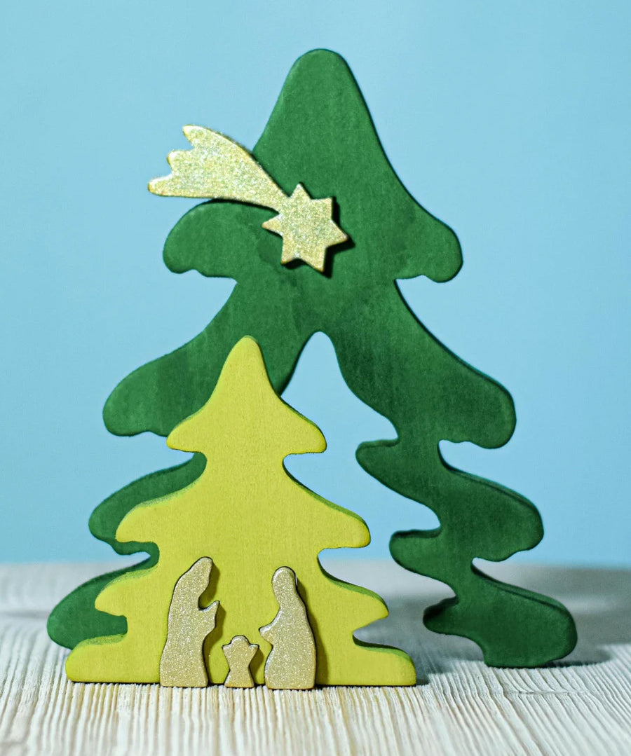 A Bumbu Christmas Tree Nativity Puzzle in the Gold colour way placed on a wooden surface. The light green tree piece has been pulled forward. 