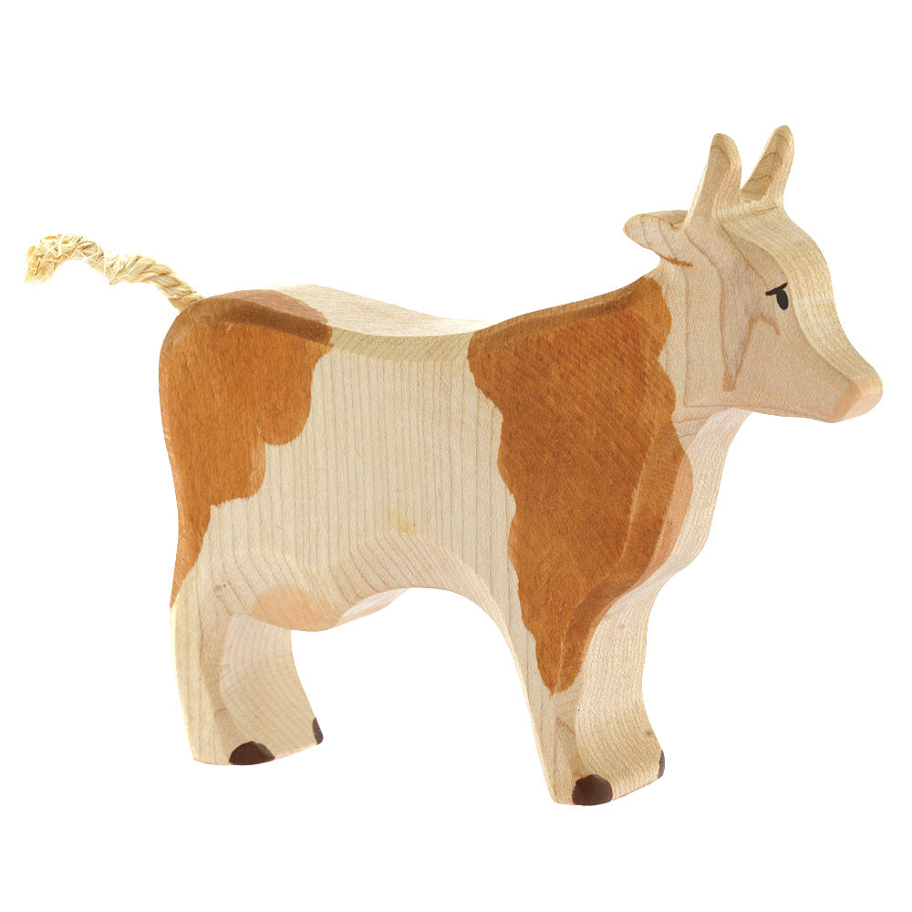 Bumbu childrens handmade brown and white wooden cow toy on a white background