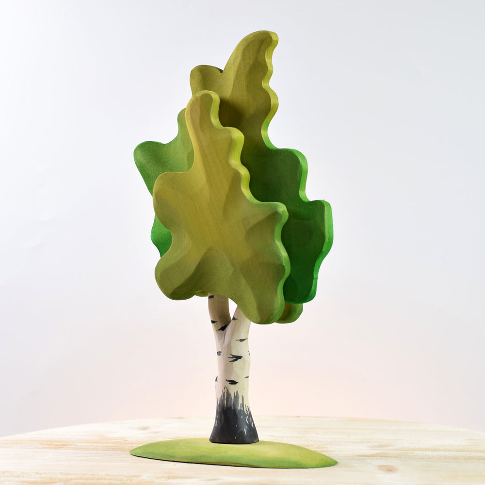 Close up of the Bumbu eco-friendly solid wooden birch tree toy on a white wooden background