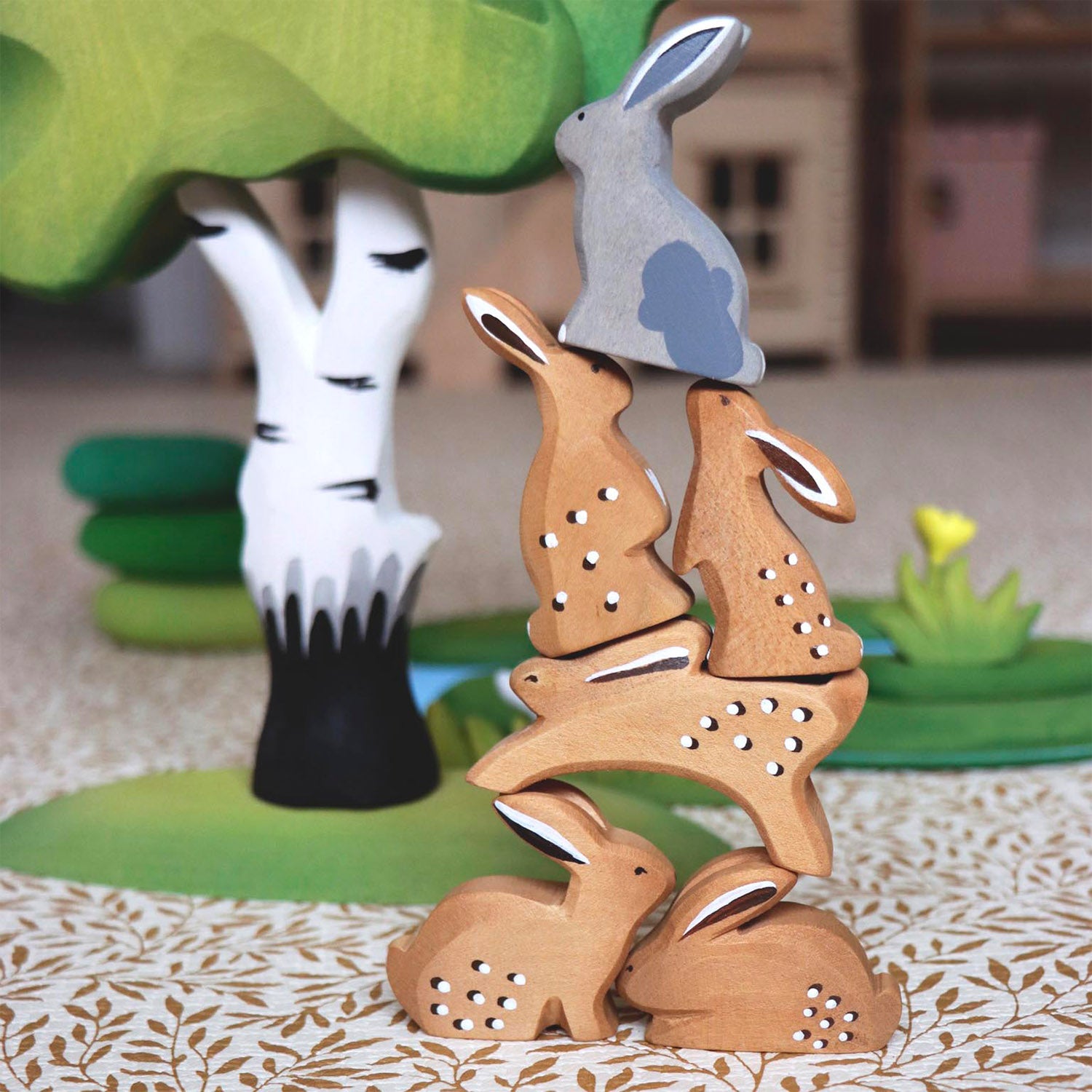 Bumbu Wooden Grey Sitting Rabbit. The grey rabbit sits aloft brown rabbits to form a pyramid.