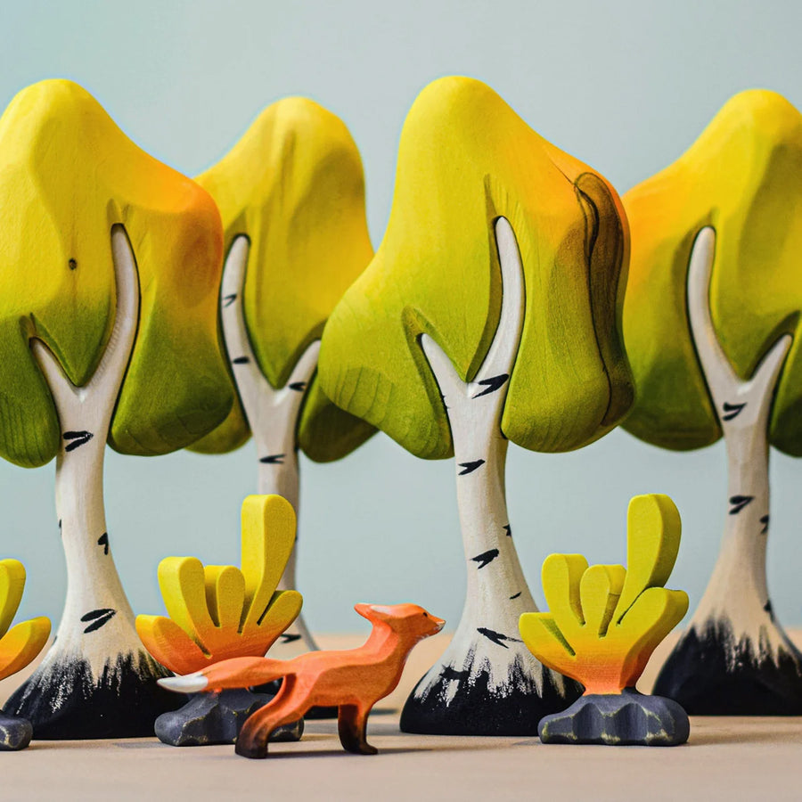 A Bumbu Wooden Fox family sit together underneath the branches of the Bumbu Wooden Birch Trees