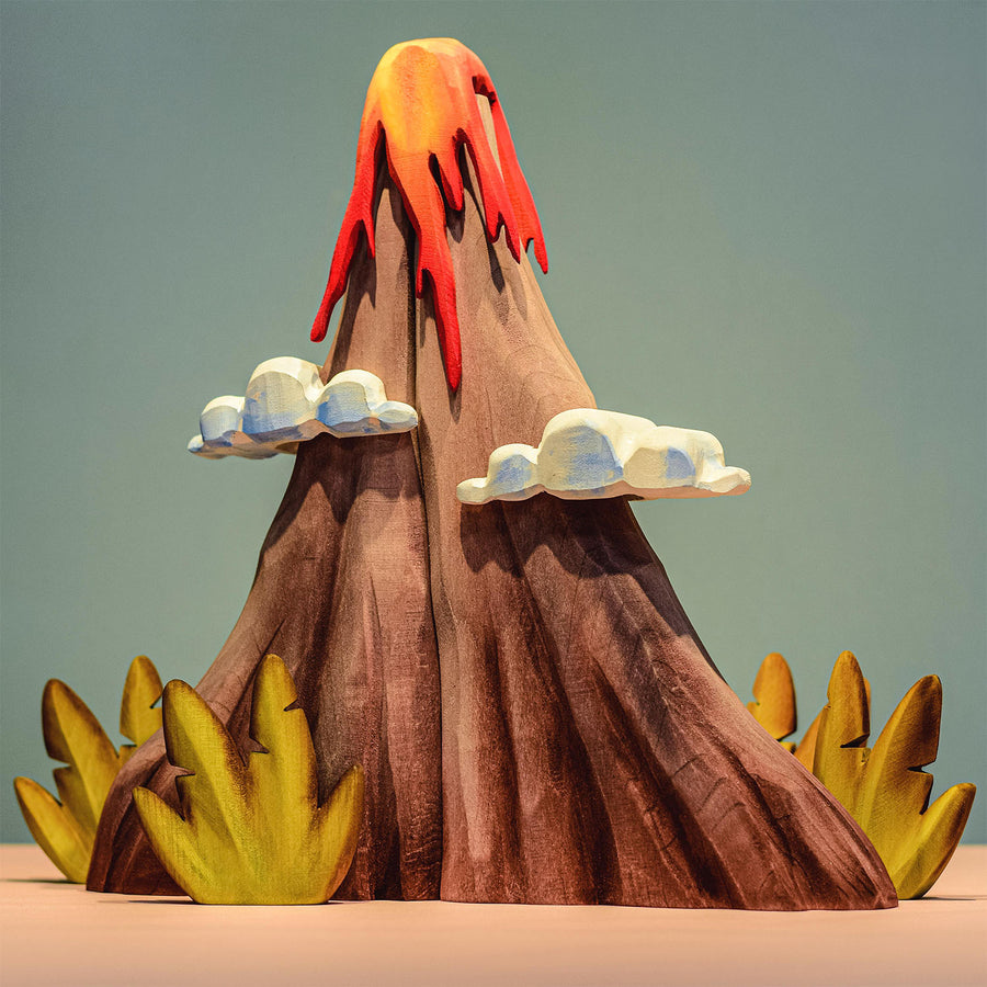 Bumbu Wooden Volcano Set. The toy is paired with Jurassic fauna.