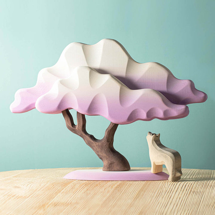 Bumbu purple winter Japanese maple tree toy on a wooden table next to a wooden wolf figure