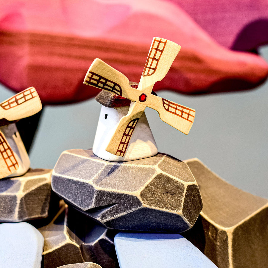 Bumbu Miniature Wooden Moldova Windmill. The toy sits on a wooden surface against a blue background. The blades and mill sit separately.