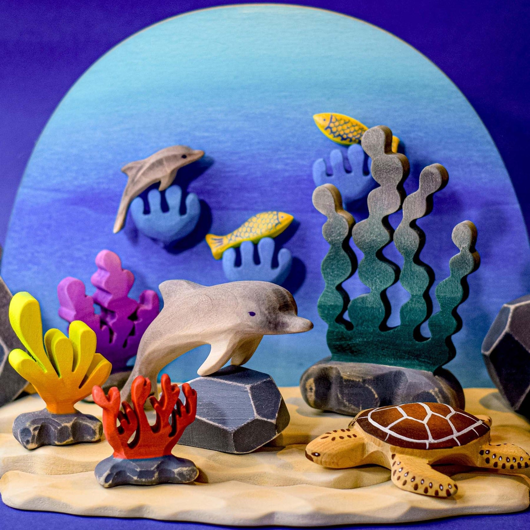 Bumbu wooden Giant Kelp toy posed in an aquatic ocean scene along with Bumbu dolphin