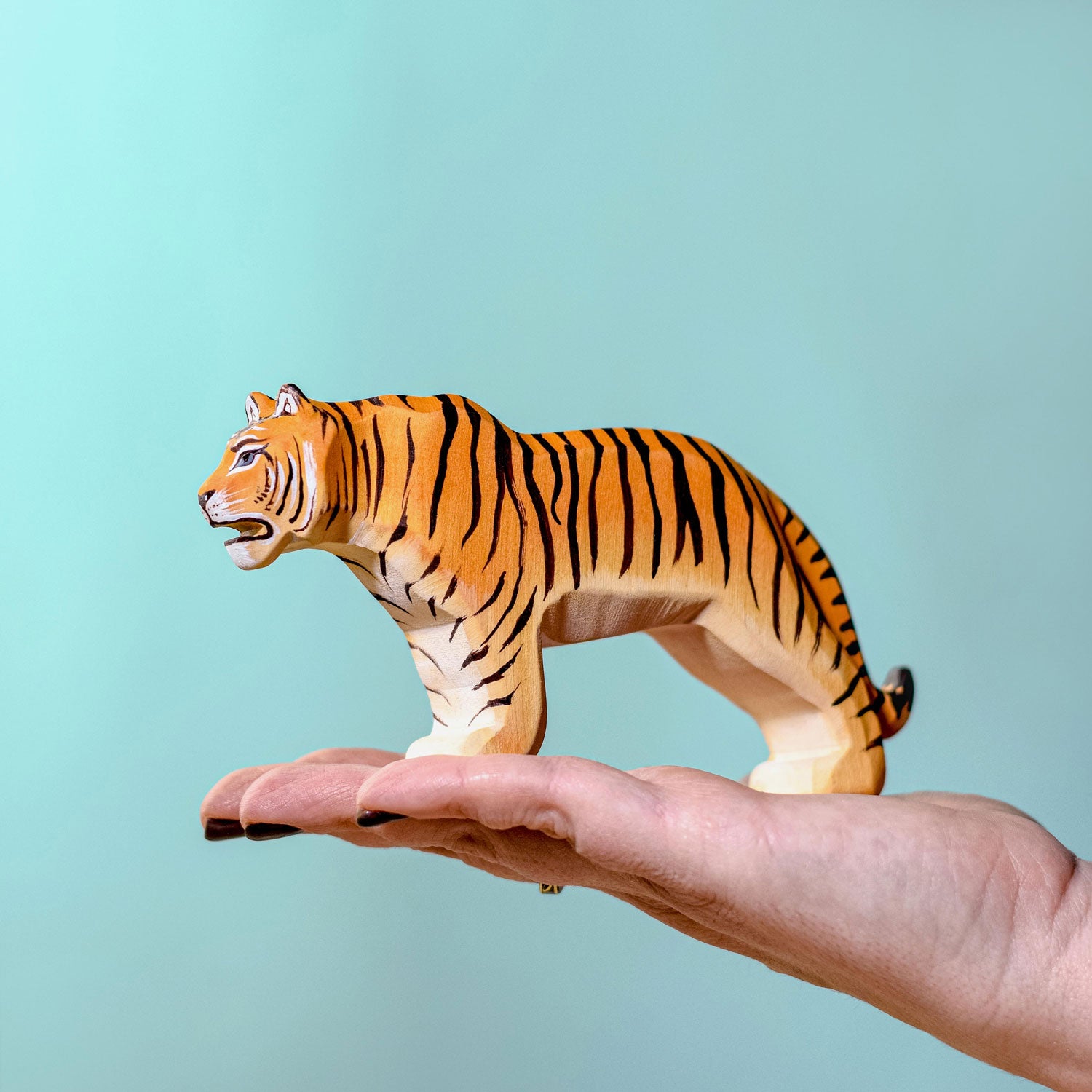 Person holding the Bumbu Wooden Standing Tiger in their hand