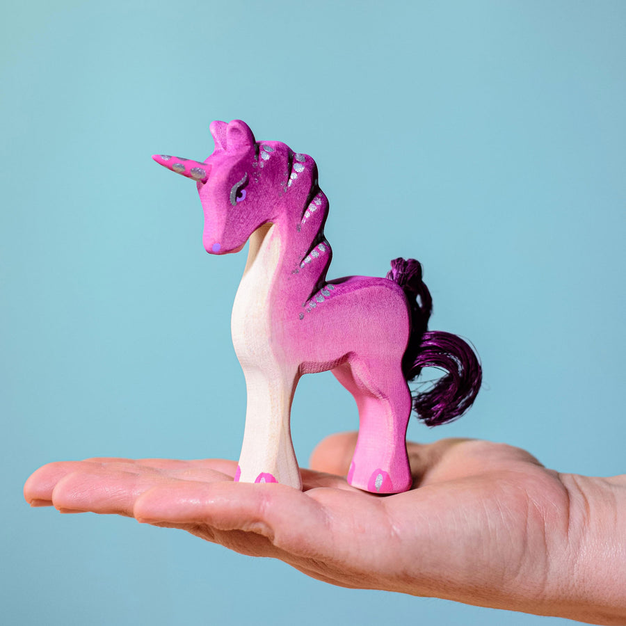 Bumbu Pink Baby Unicorn  pictured in an adults hand