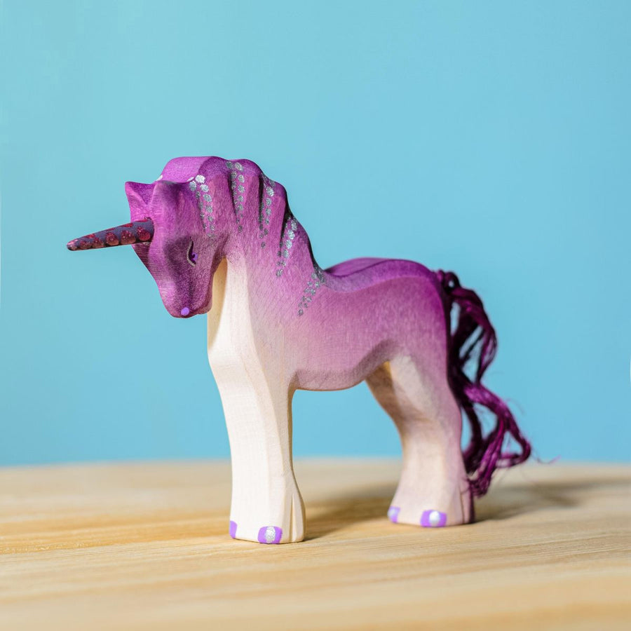 Bumbu Pink Unicorn pictured on a wooden surface with a blue wall in the background