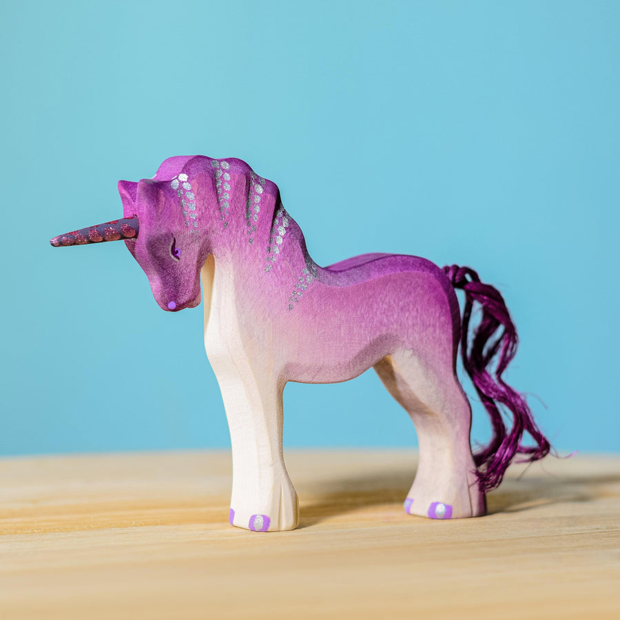 Bumbu Pink Unicorn pictured on a wooden surface with a blue wall in the background