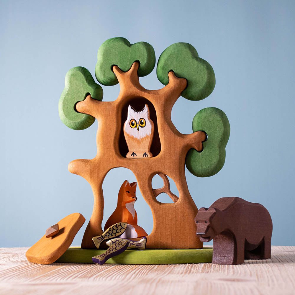 Bumbu brown wooden bear figure on a wooden table next to the Bumbu ancient oak tree set