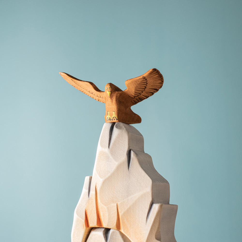 Close up of the Bumbu plastic-free wooden eagle figure on top of a wooden rock