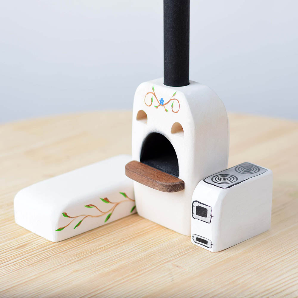 Close up of the Bumbu plastic-free wooden oven and stove toy set on a wooden worktop