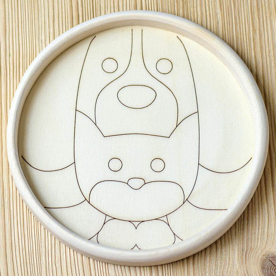 Empty wooden circular block puzzle with a stenciled outline to show the form of a cat and dog.