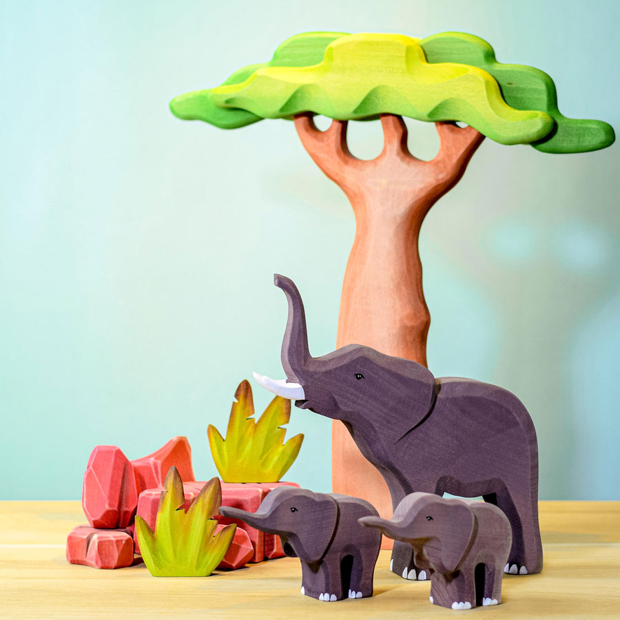 A Bumbu Wooden Banana Bush surrounded by family of moose figures