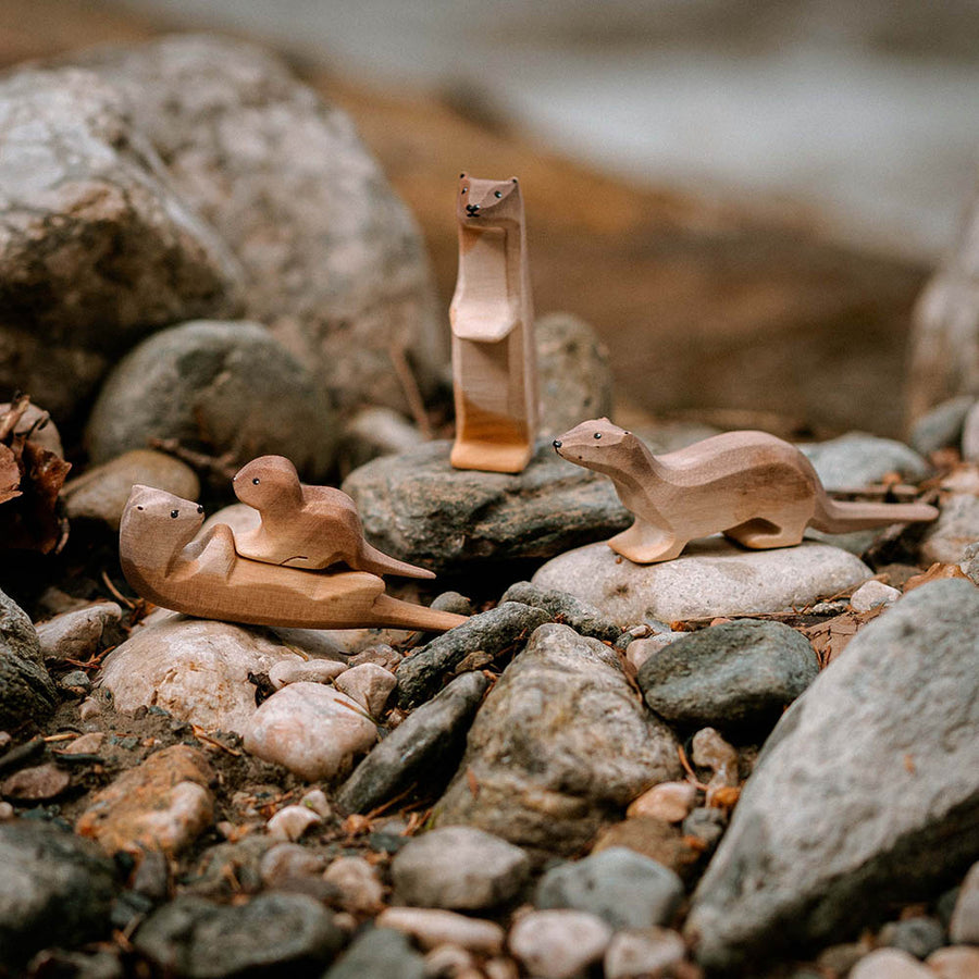 Bumbu wooden otter animal toys stood on some small pebbles