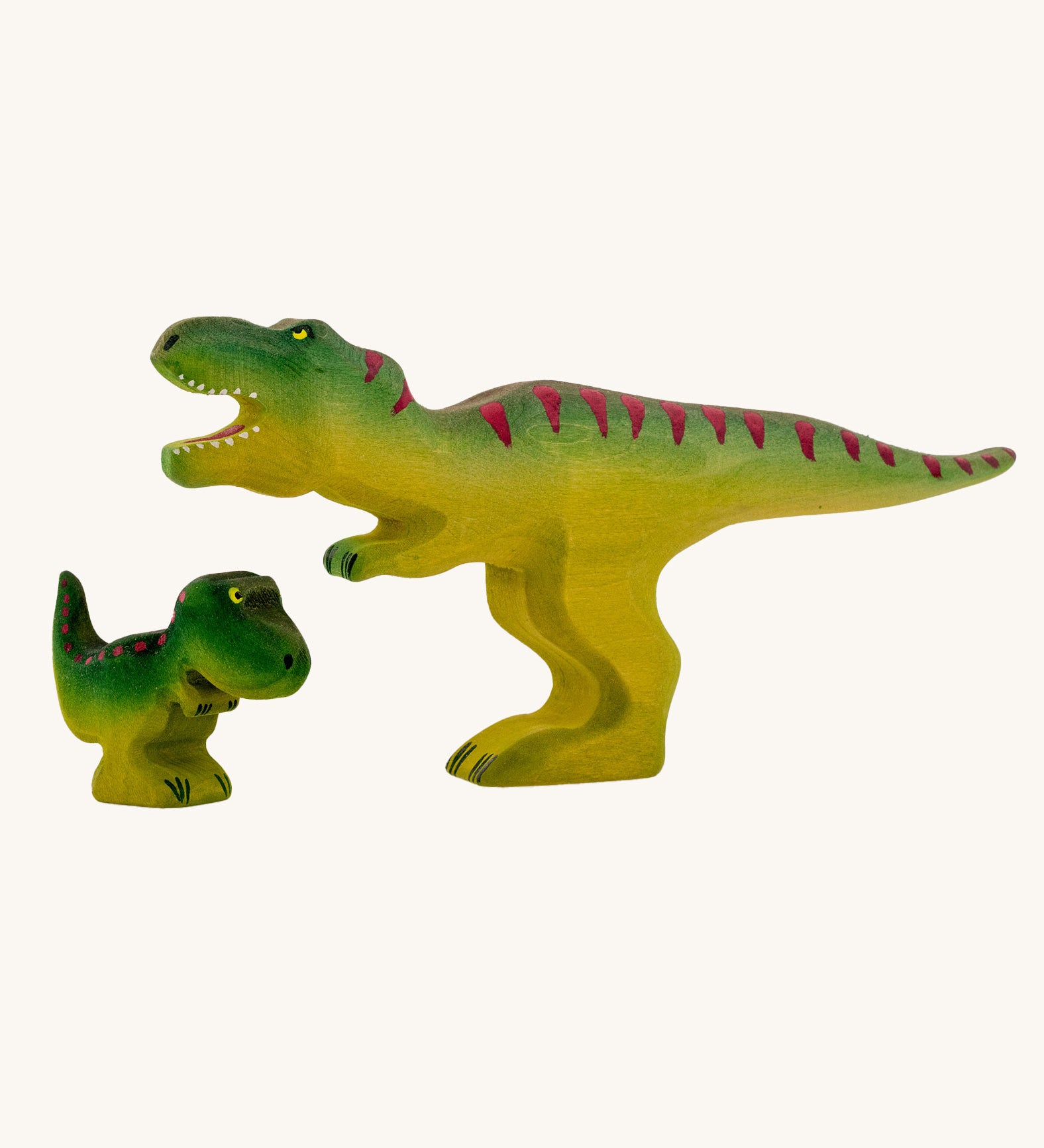 Bumbu Baby and large Wooden T-Rex Dinosaurs on a plain background.