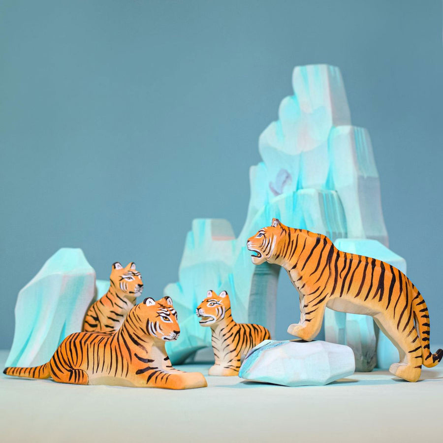 Tiger family standing in front of bumbu icy cliffs