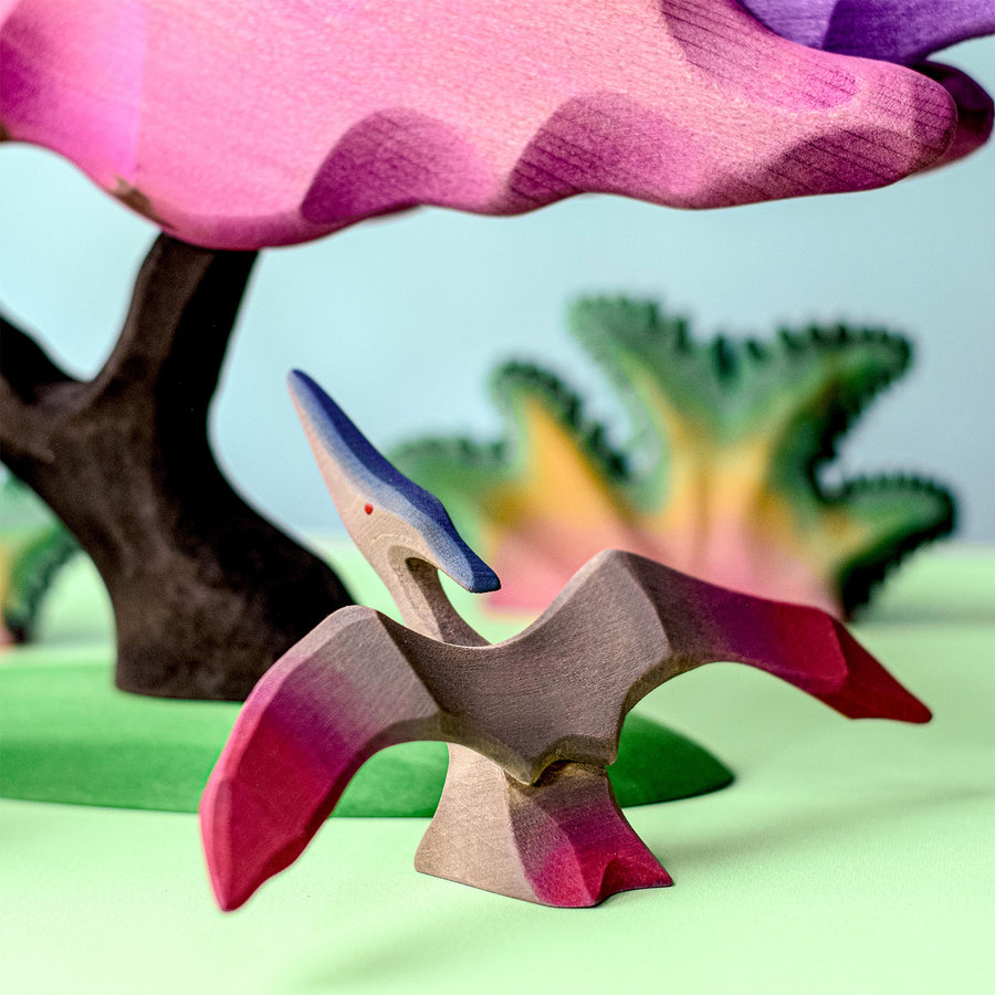 Bumbu Wooden Pteranodon Dinosaur. The toy sits within a Jurrasic setting.