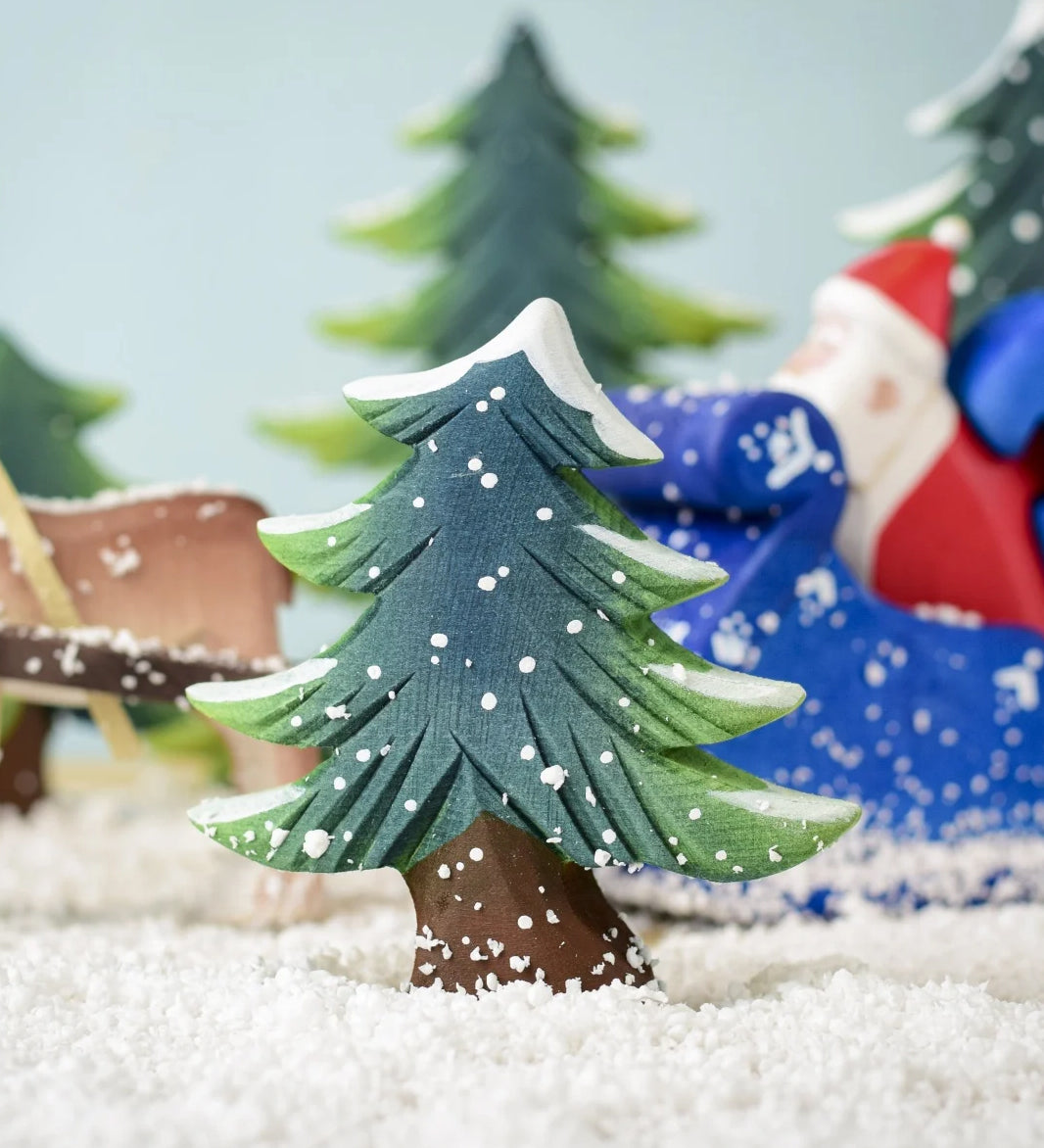 A Bumbu Small Snowy Fir Tree placed in the centre of a festive small world play scene. 