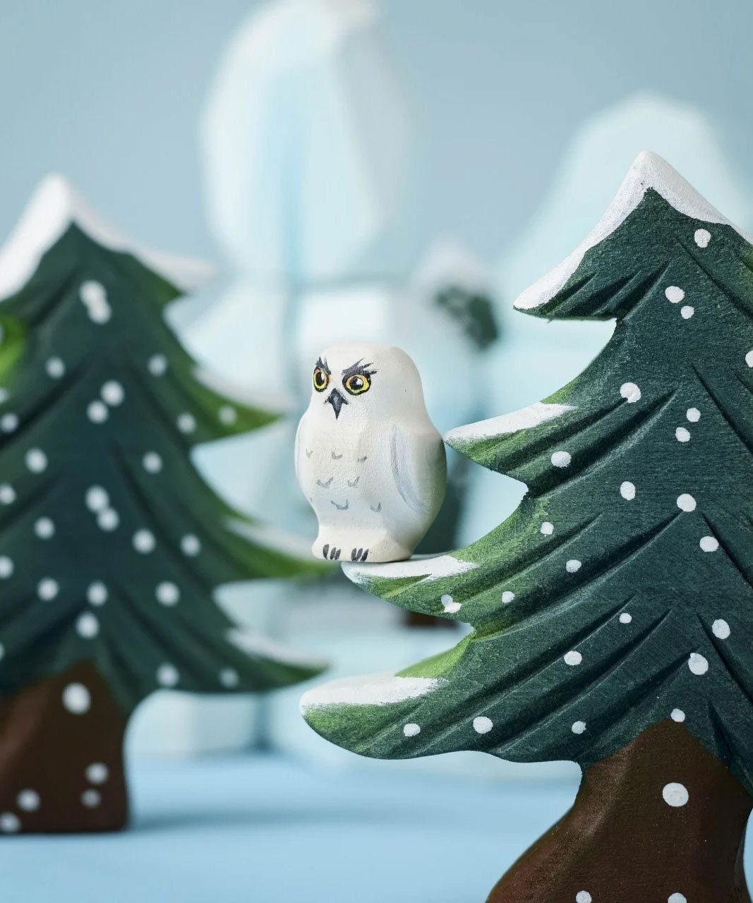 A Bumbu Toys Snowy Owl Chick sitting on a branch of the Bumbu snowy tree. 