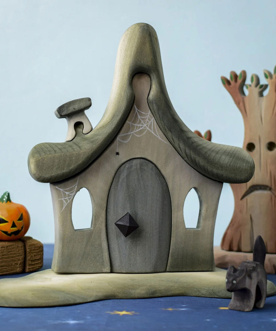 Bumbu Toys Witches house placed in the centre of a Halloween themed small world play set up. 