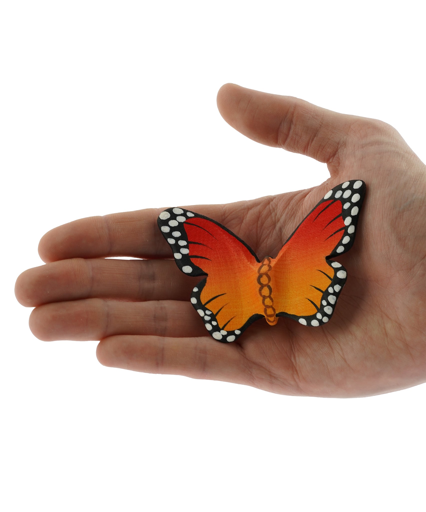 Bumbu Wooden Butterfly Figure pictured in an adult's hand on a plain background 