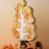 A small world play set up featuring the Bumbu Toys Big Puzzle Birch Tree with Bumbu pumpkins, wooden bales and foxes.