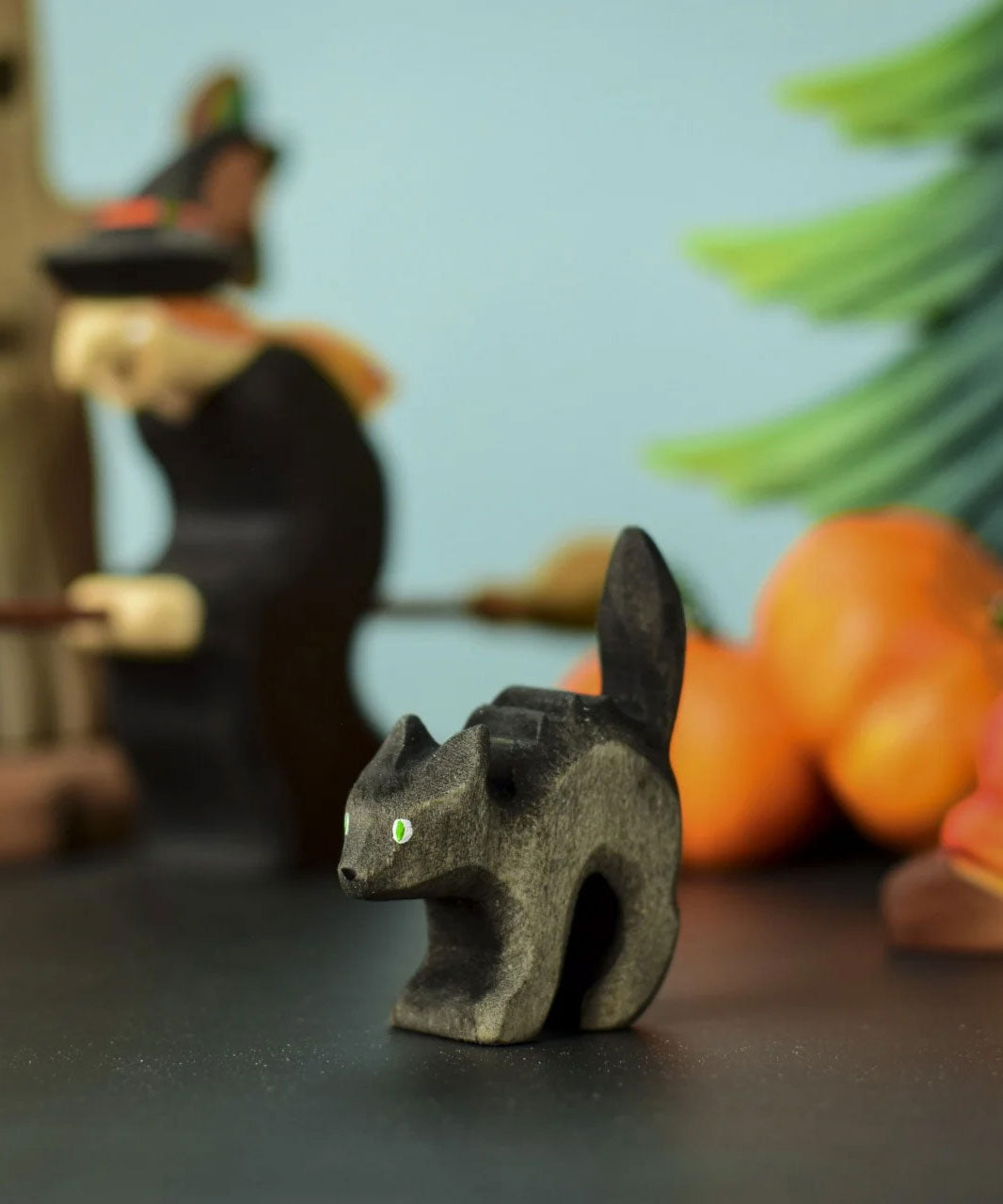 Bumbu Toys Scared Black Cat figure. The cat's tail is stood up and the cat has green eyes. The cat is placed at the front of a Halloween themed play scene. 