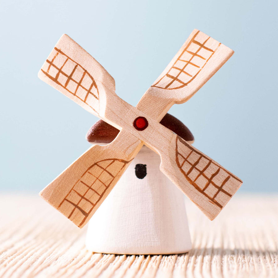 Bumbu Miniature Wooden Moldova Windmill. The toy sits on a rock in a waterfall scene.