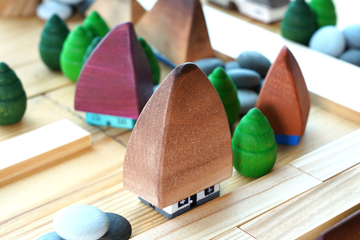 Bumbu eco-friendly wooden Transylvania houses on a wooden table next to some grapat mandala trees