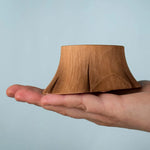 Bumbu wooden tree stump resting on a adult hand