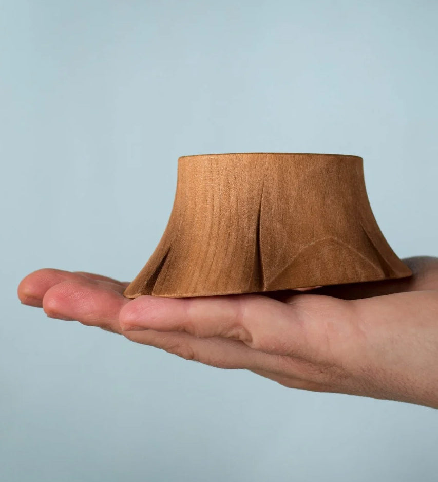 Bumbu wooden tree stump resting on a adult hand