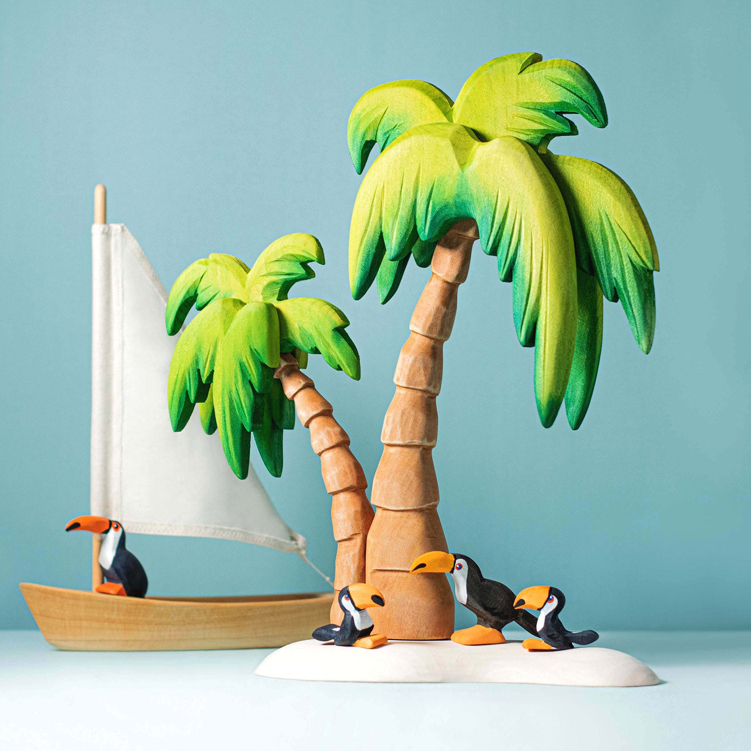 Bumbu Wooden Palm Tree. The toy is paired with a boat and several toucans.