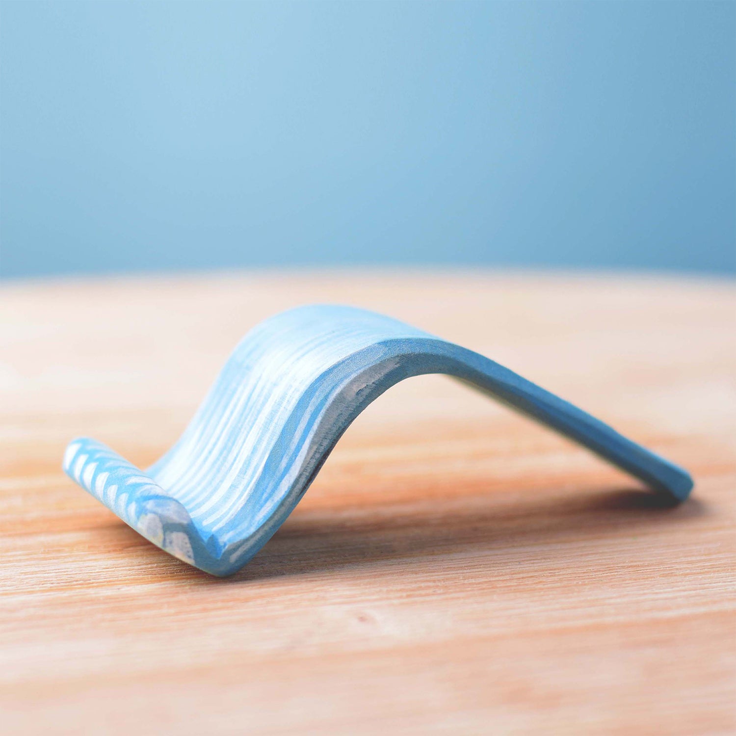 Bumbu Wooden Waterfall. The toy sits on a wooden surface against a blue background.