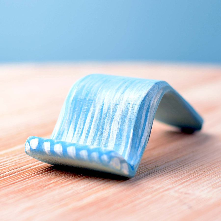 Bumbu Wooden Waterfall. The toy sits on a wooden surface against a blue background.