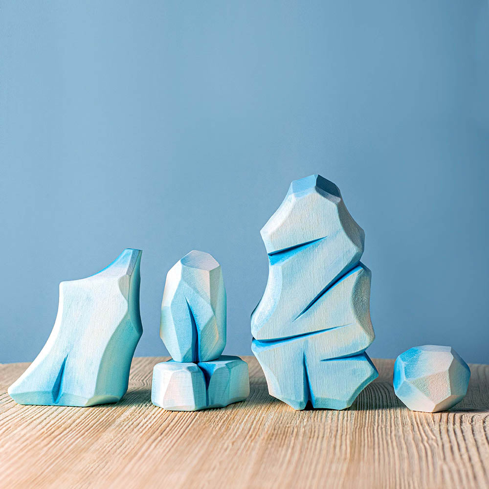 penguins and swans laid out on a light blue background in front of some Bumbu Waldorf icy rocks and white Maple tree toys