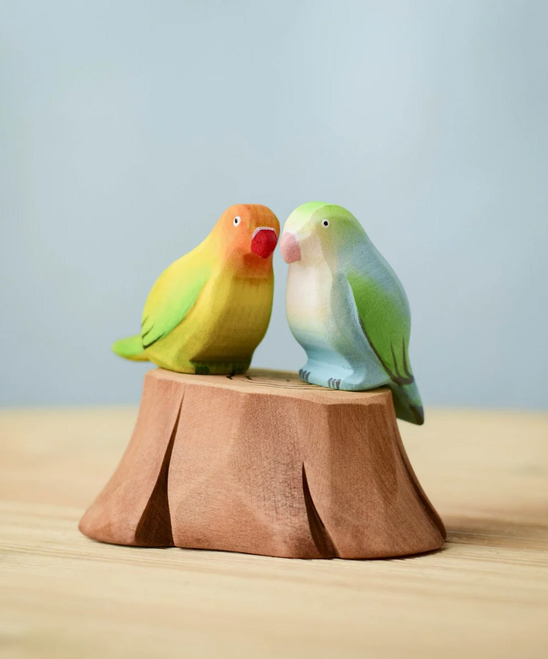 Bumbu wooden blue and lovebird figures perched on a Bumbu wooden stump